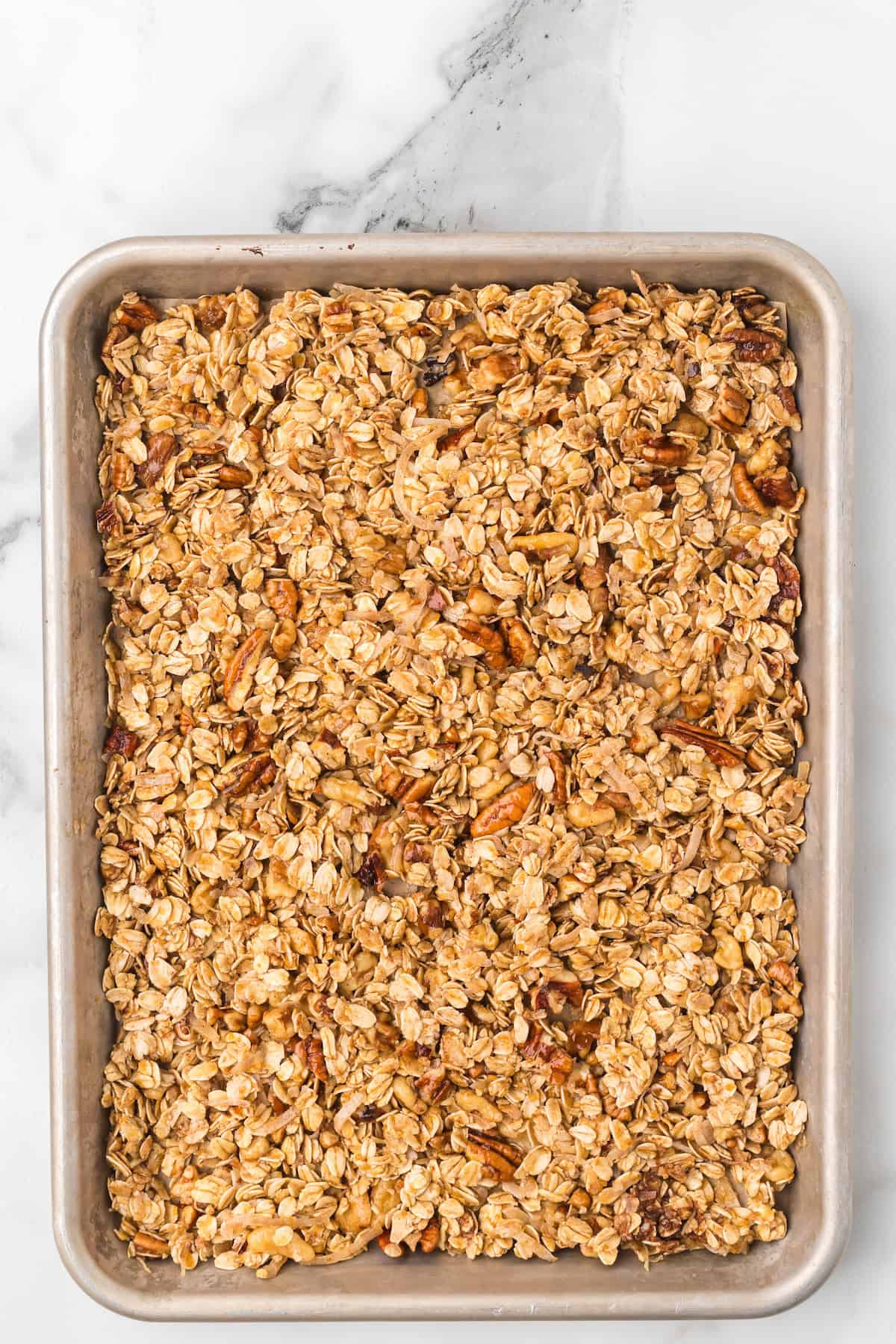 Unbaked apple pie granola mixture spread evenly on a baking sheet, ready to go into the oven.