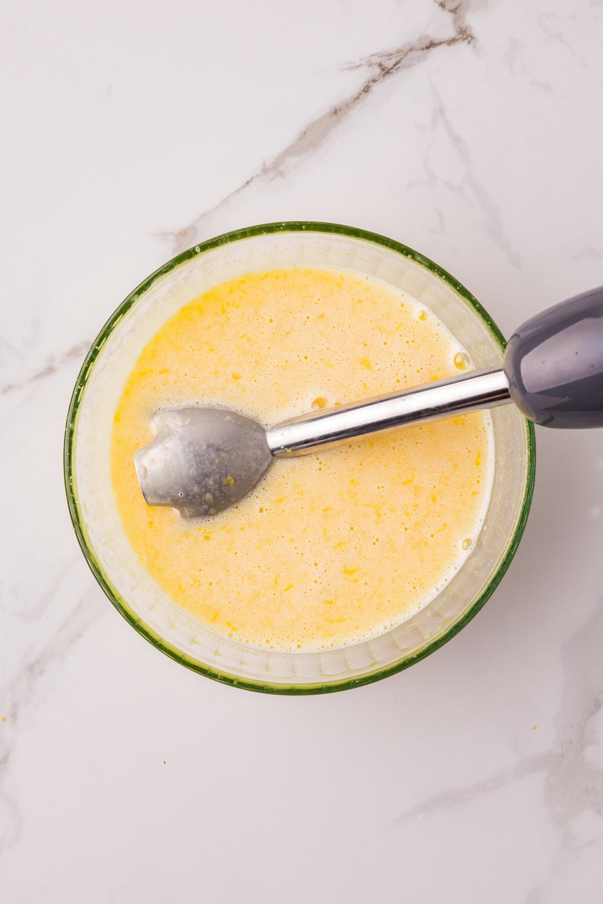 Blending the lemon curd mixture with an immersion blender until smooth.