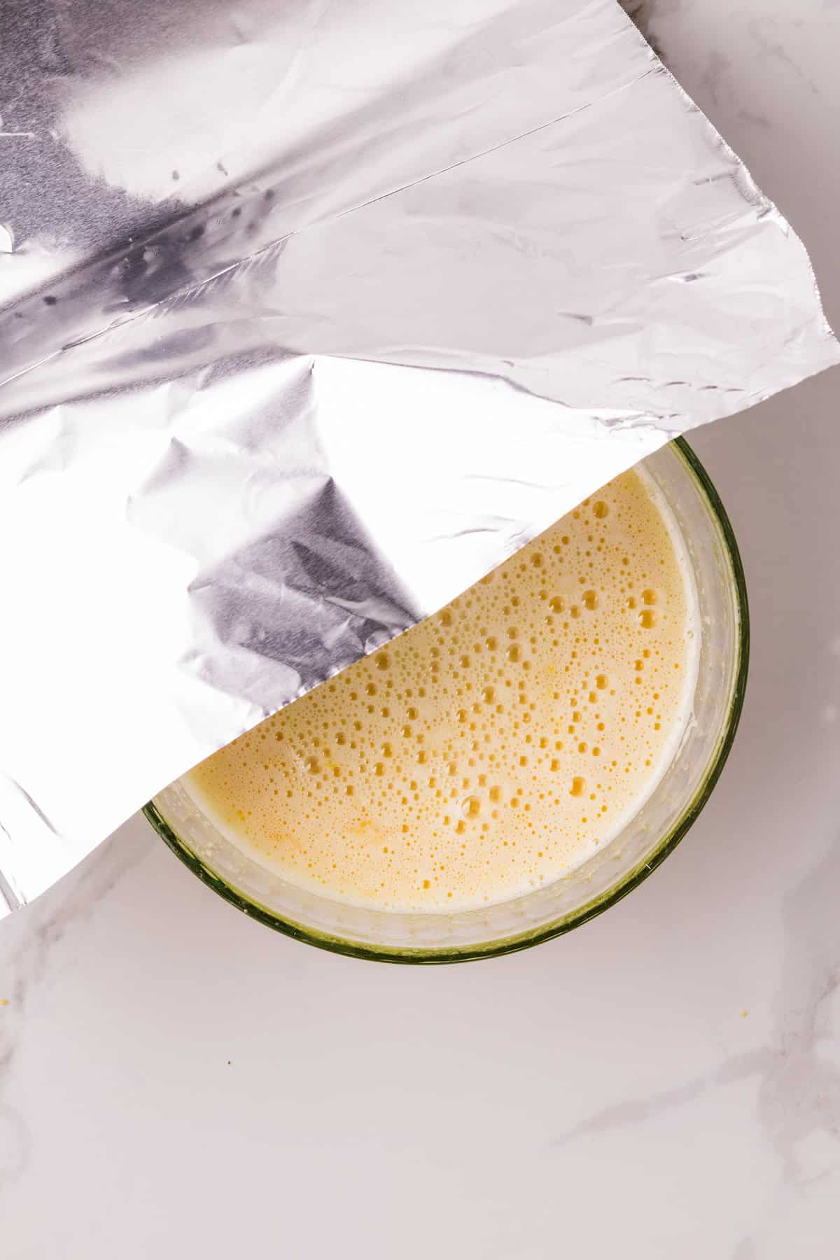 Covering the lemon curd mixture with foil before cooking it in the Instant Pot.