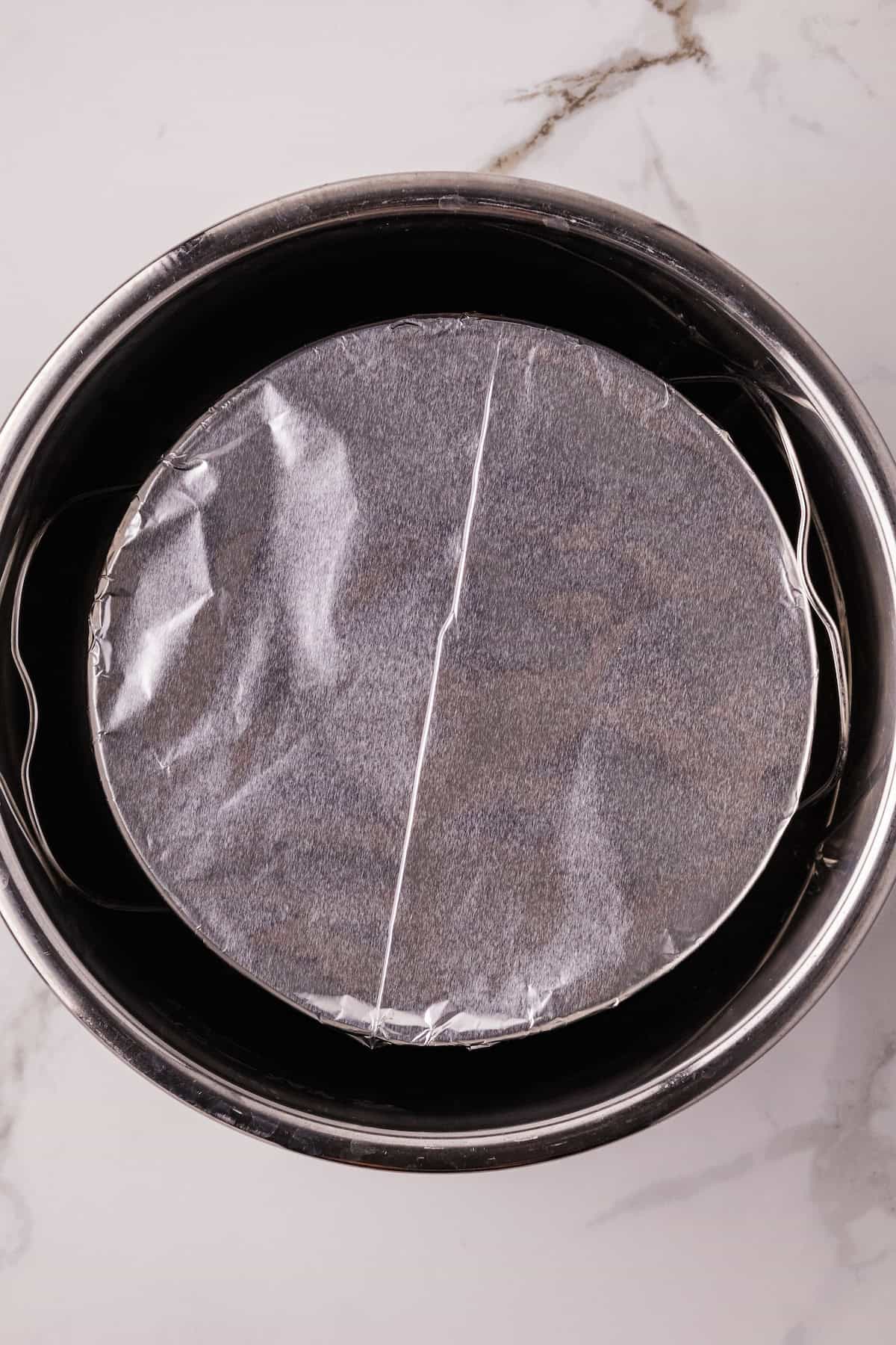 Foil-covered bowl placed on the trivet inside the Instant Pot to cook lemon curd.