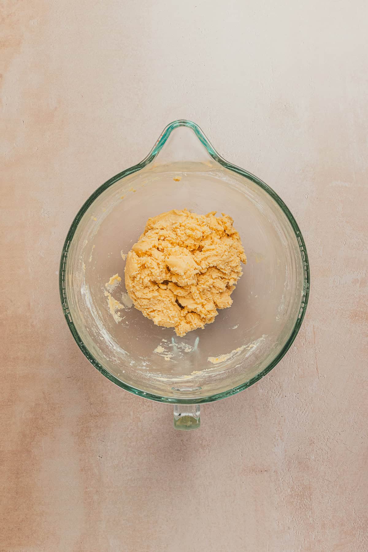 Soft lemon cookie dough fully mixed and ready for chilling in a glass bowl.
