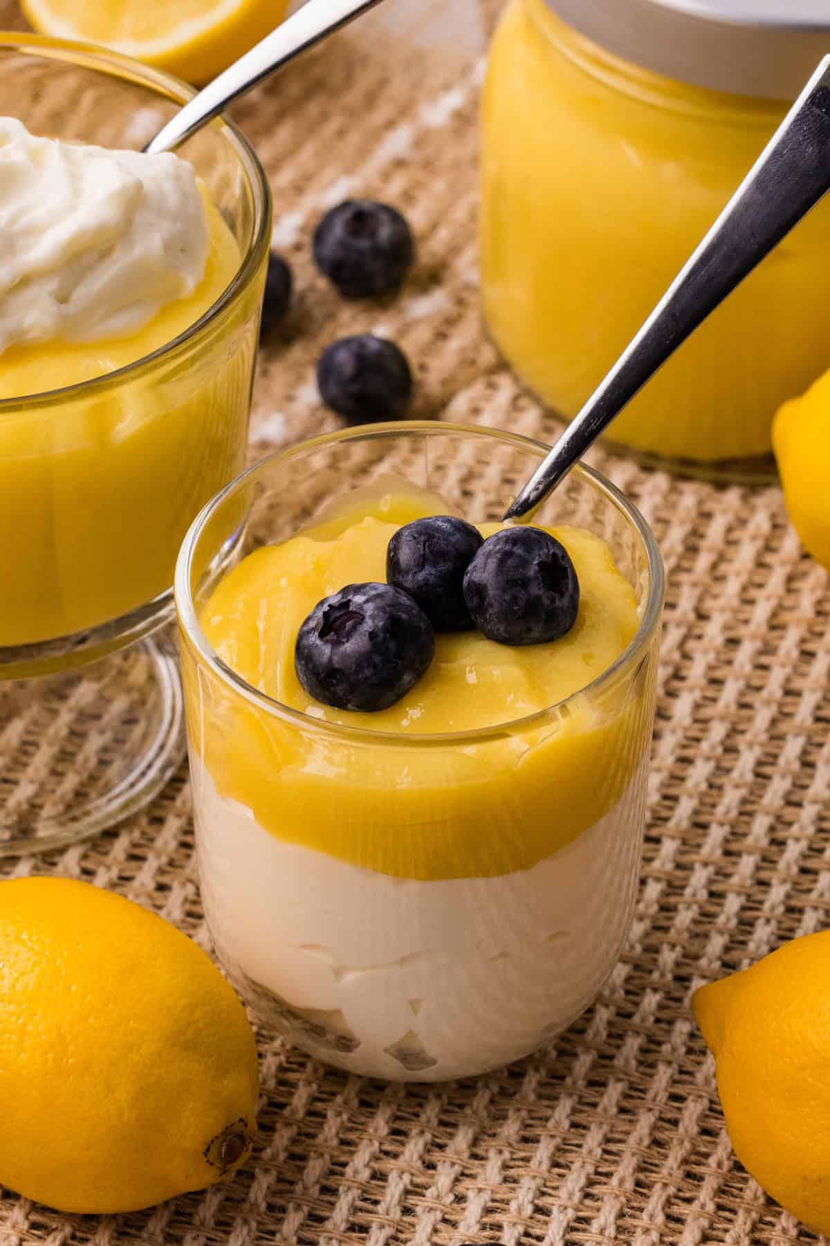 Lemon curd dessert served in a glass with fresh blueberries on top.