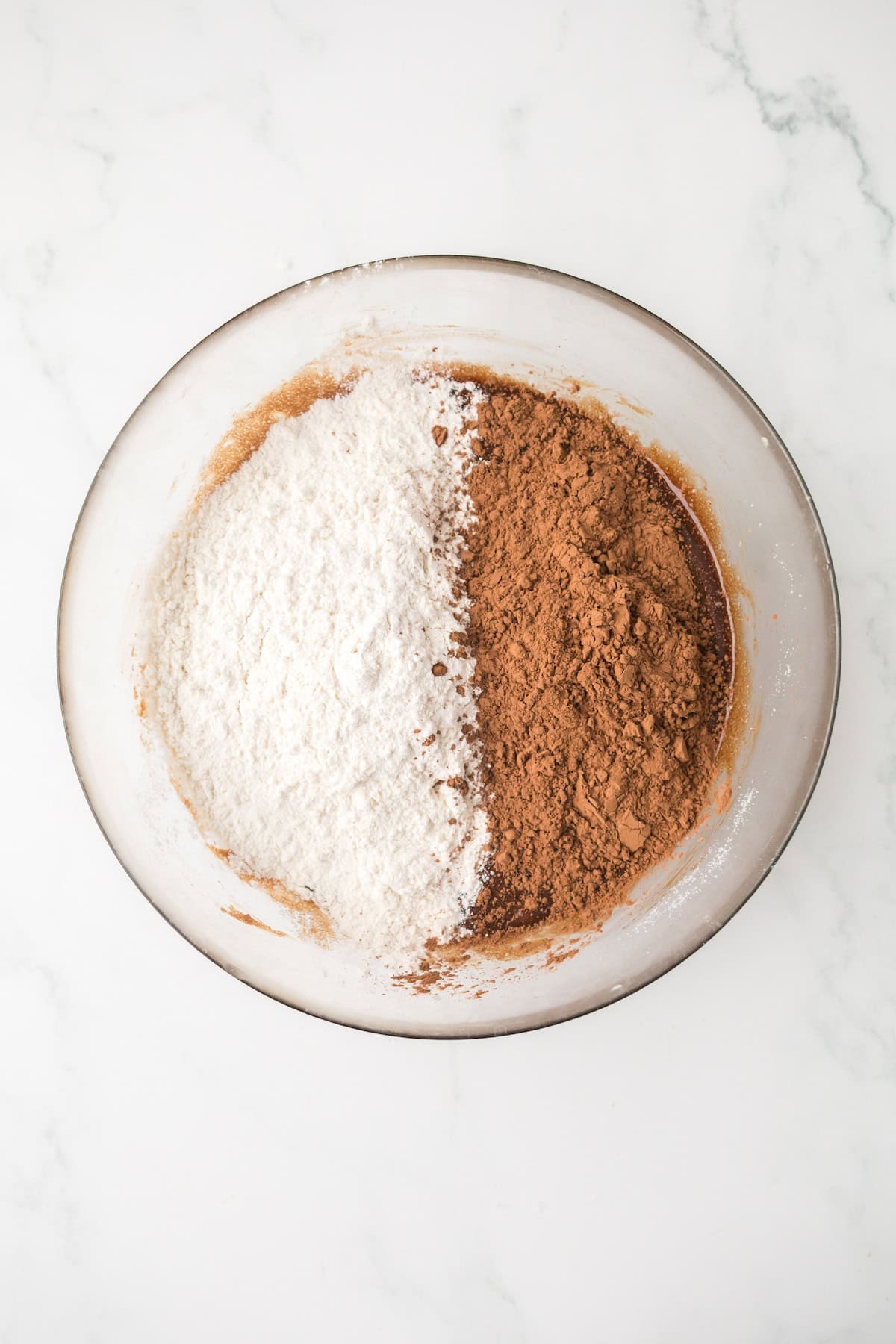 Flour and cocoa powder added to brownie cookie dough mixture.