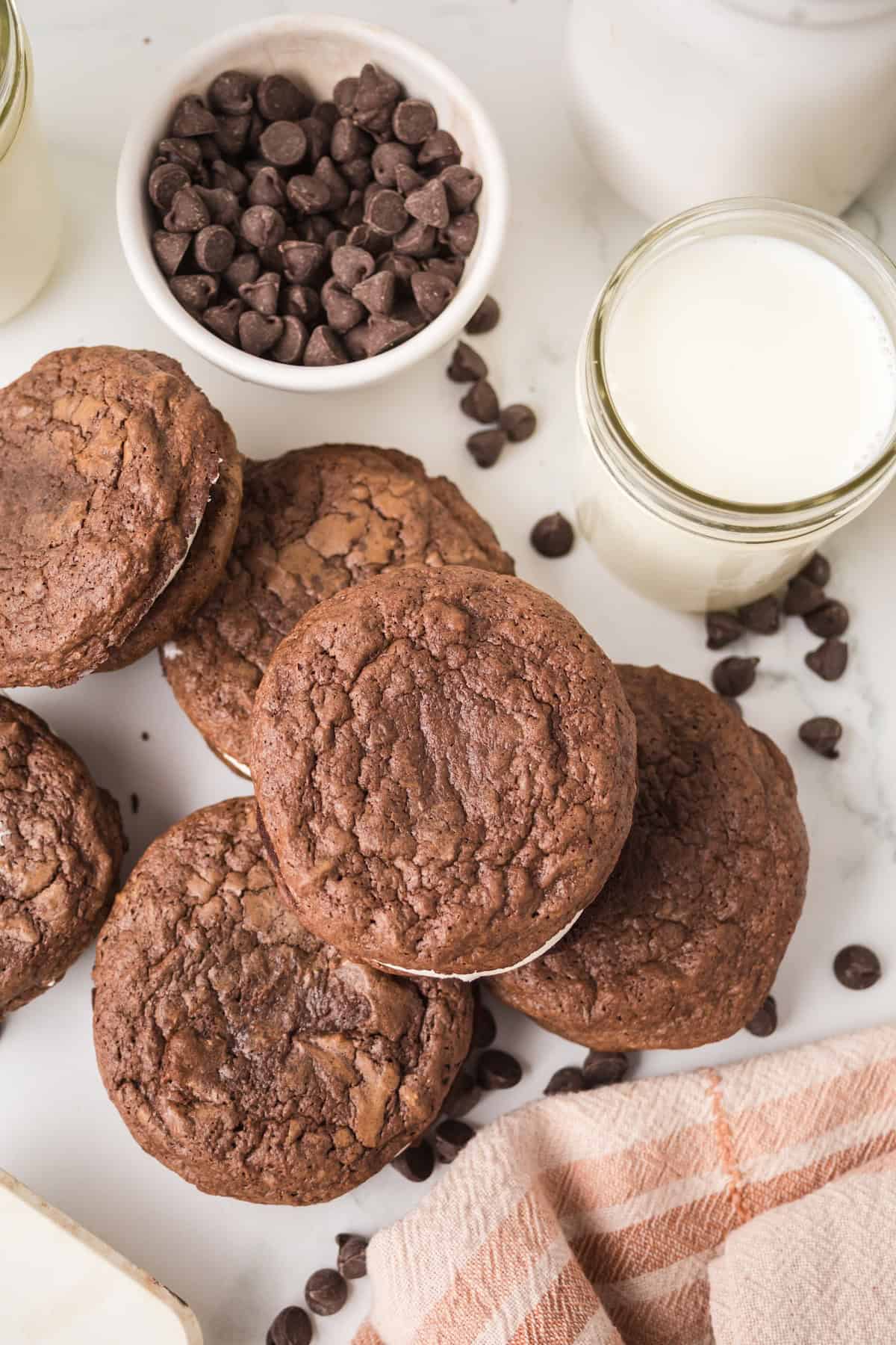 Overhead view of brownie cream pies with chocolate chips and a glass of milk.