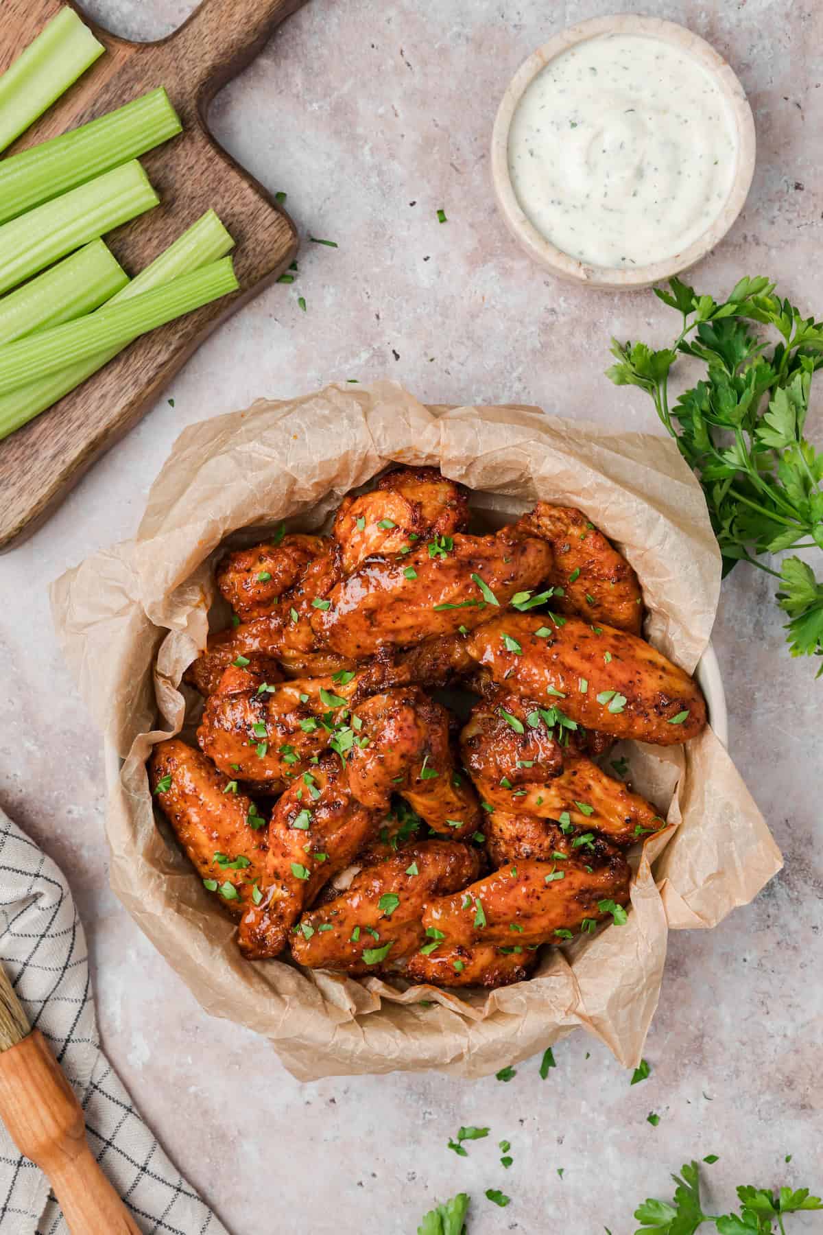 Cajun chicken wings served in a bowl with celery sticks and ranch dipping sauce.