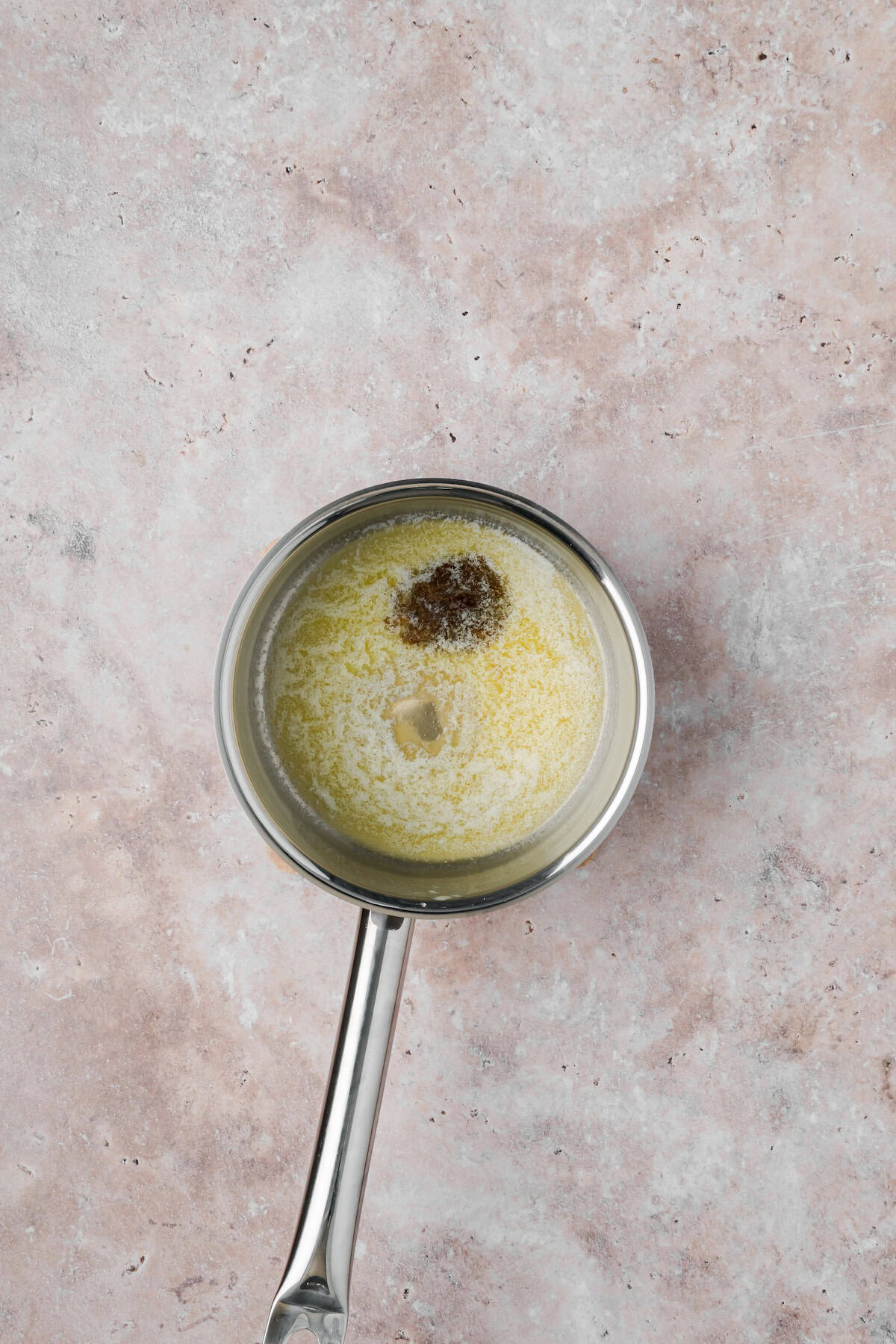 Melted butter with Cajun seasoning in a saucepan for wing sauce.