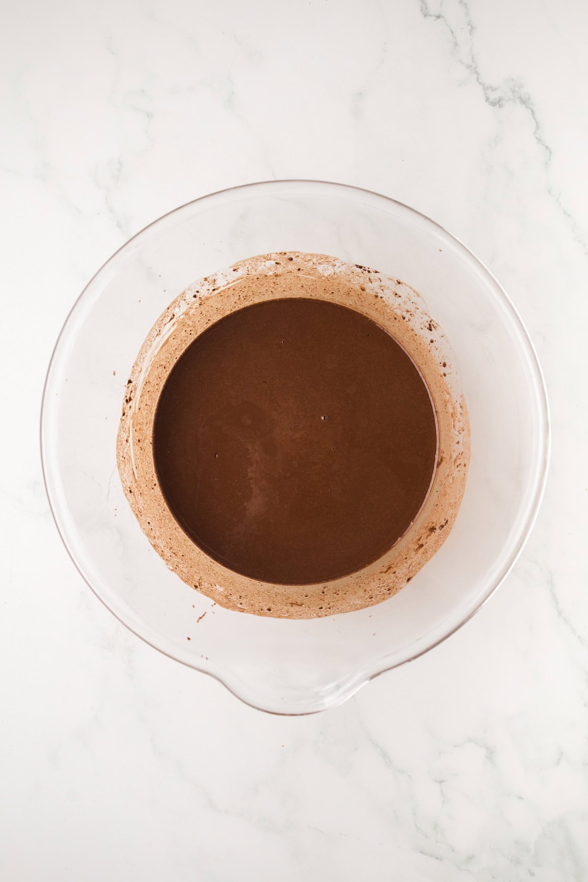 Chocolate mixture made with cocoa powder, butter, and hot water for homemade ding dongs.
