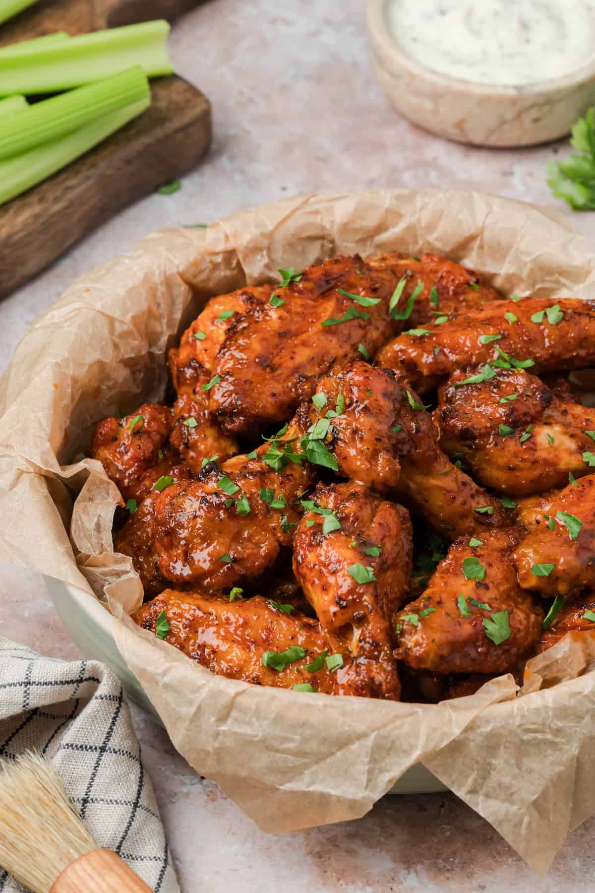 Homemade Cajun chicken wings served in a bowl with celery and ranch on the side.