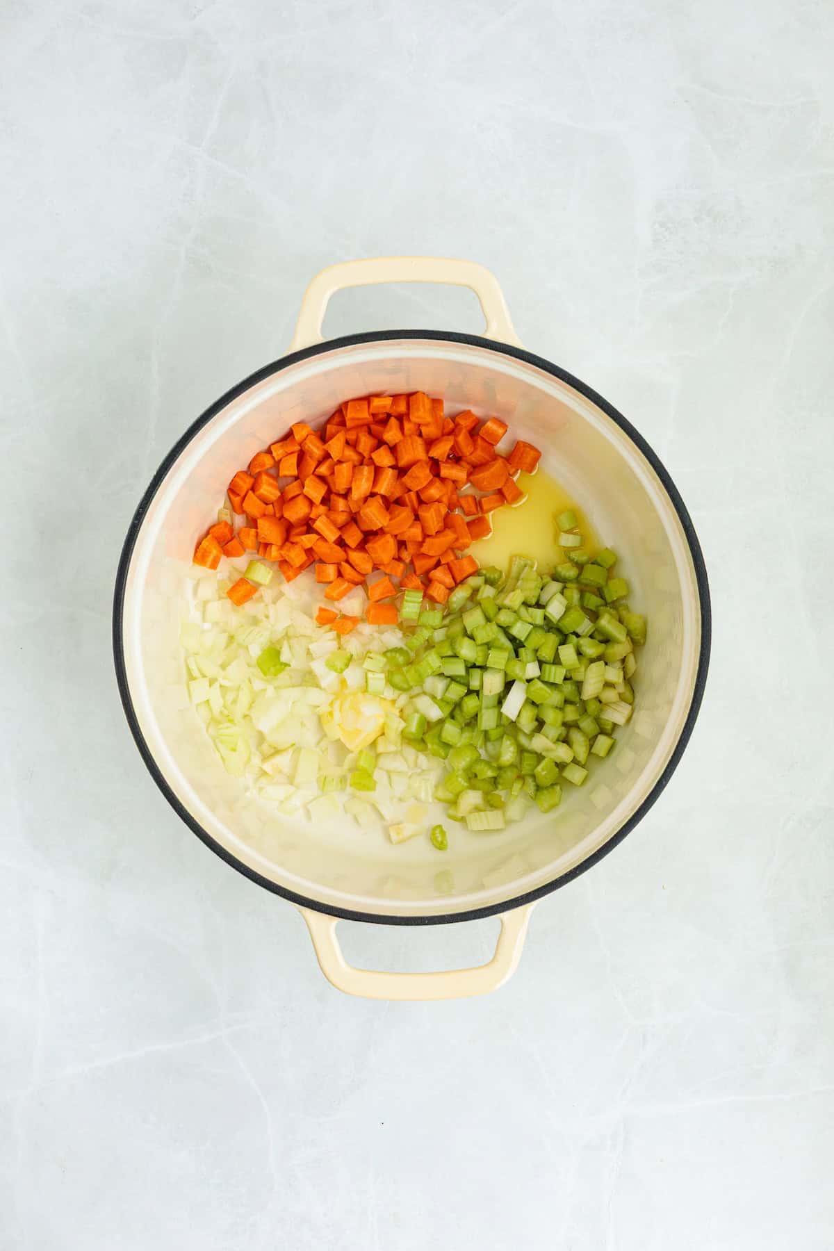 Fresh onions, carrots, celery, garlic, and butter in a Dutch oven to start homemade lemon chicken orzo soup.